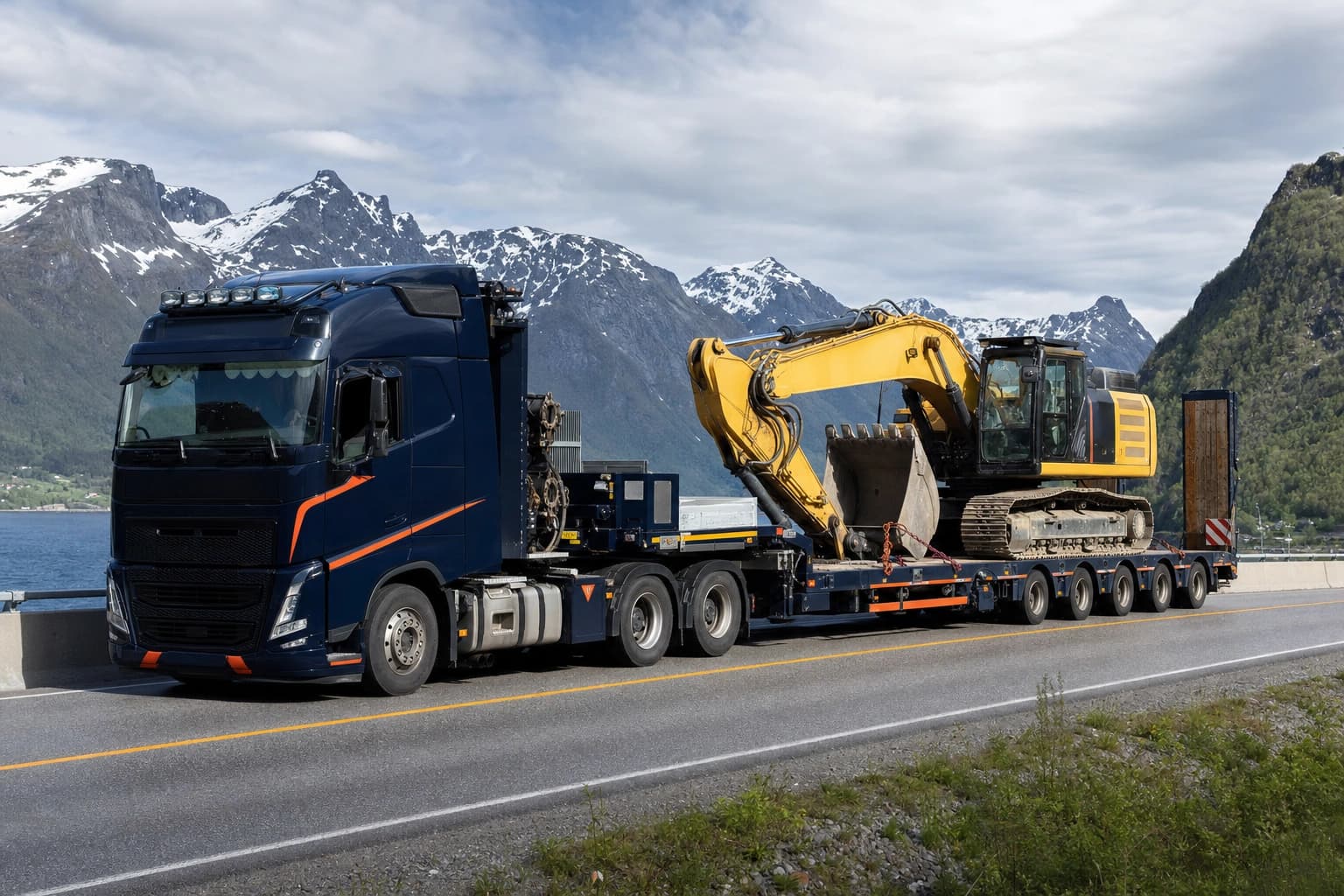 Apila trailer transporterer gravemaskin på lavtrailer på norsk motorvei