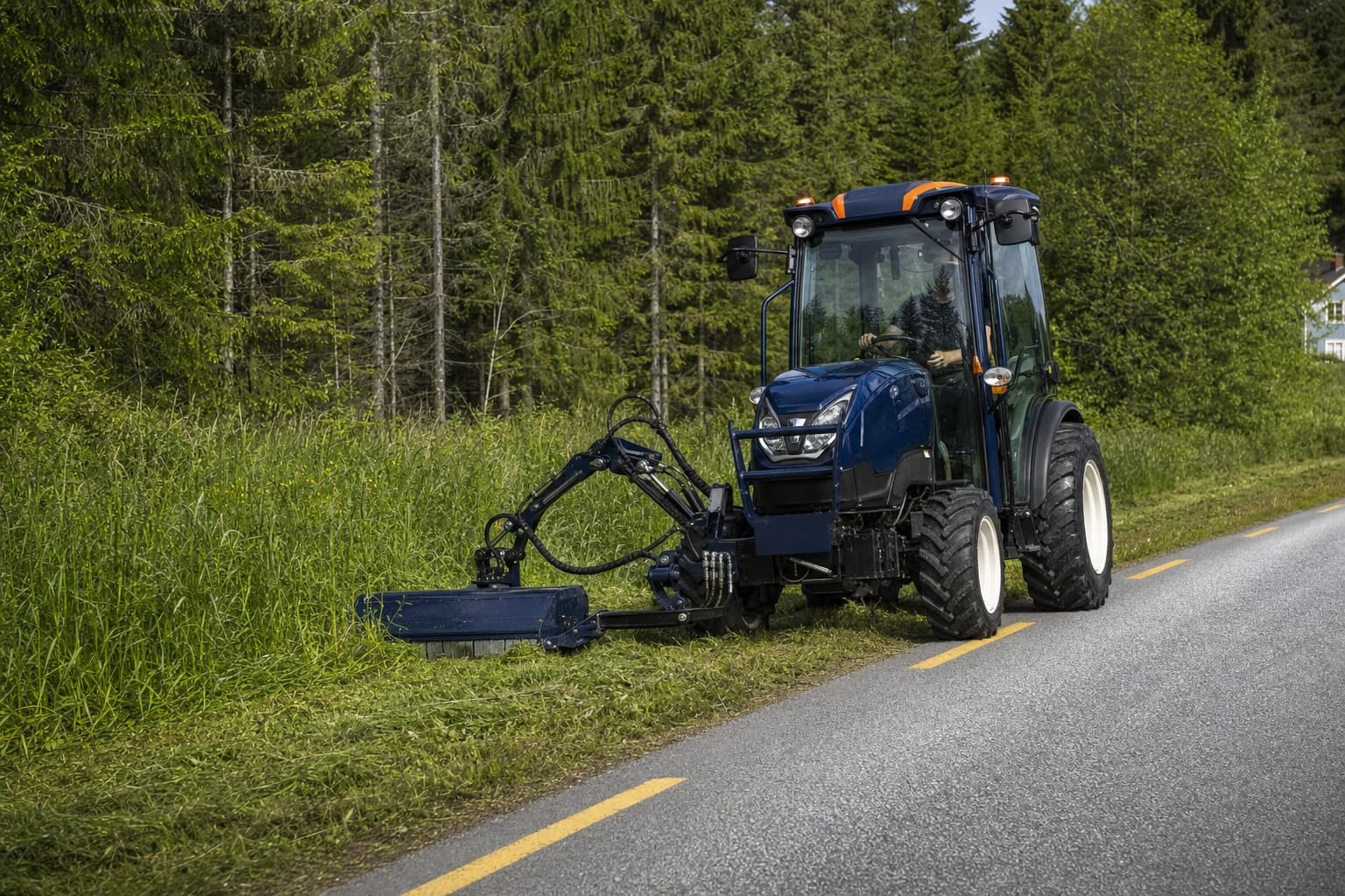 Apila traktor med sideklipper utfører kantslått langs en norsk landevei